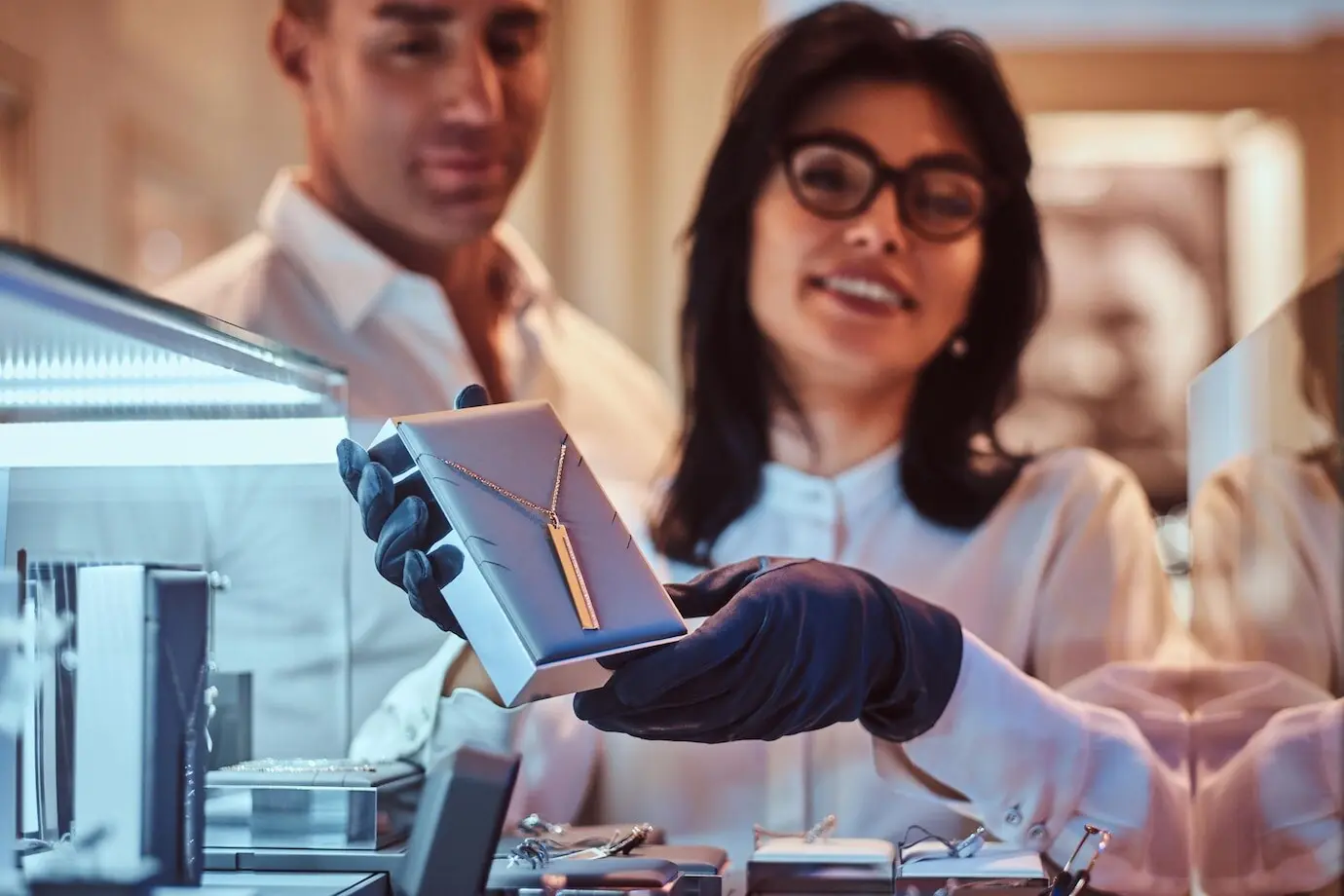 Сотрудница демонстрирует эксклюзивное золотое ожерелье в роскошном ювелирном магазине.